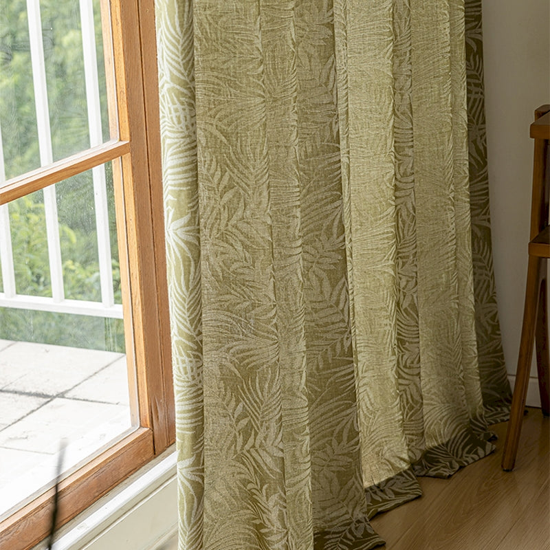 a window with a curtain and a chair in front of it