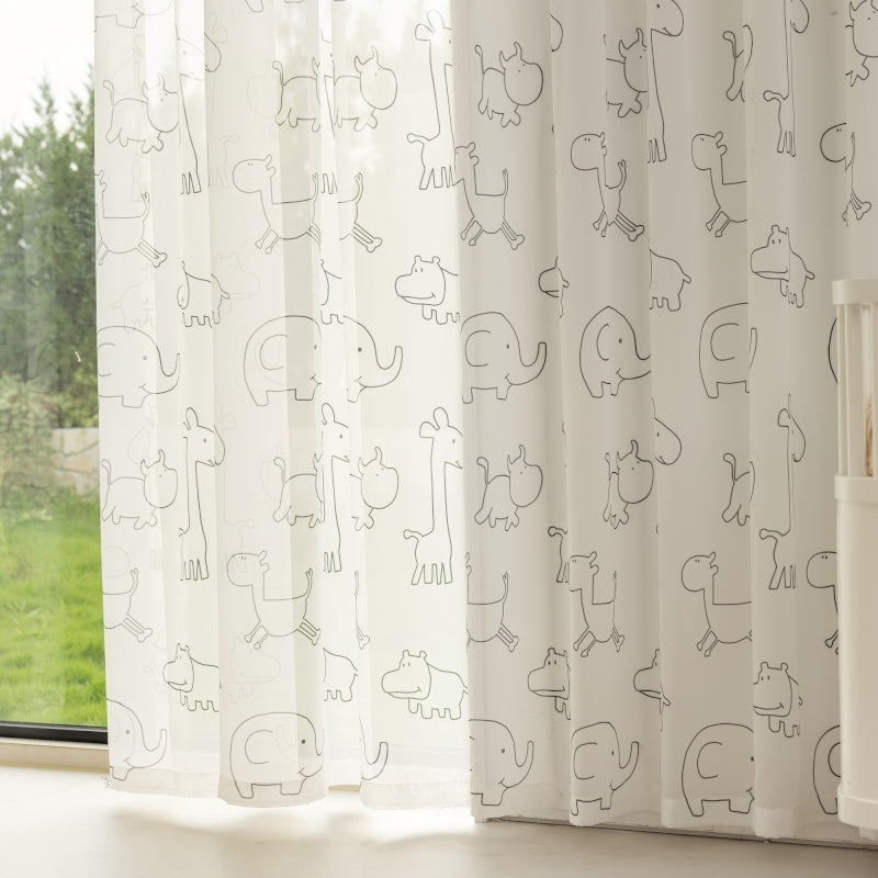 a baby crib next to a window with a curtain