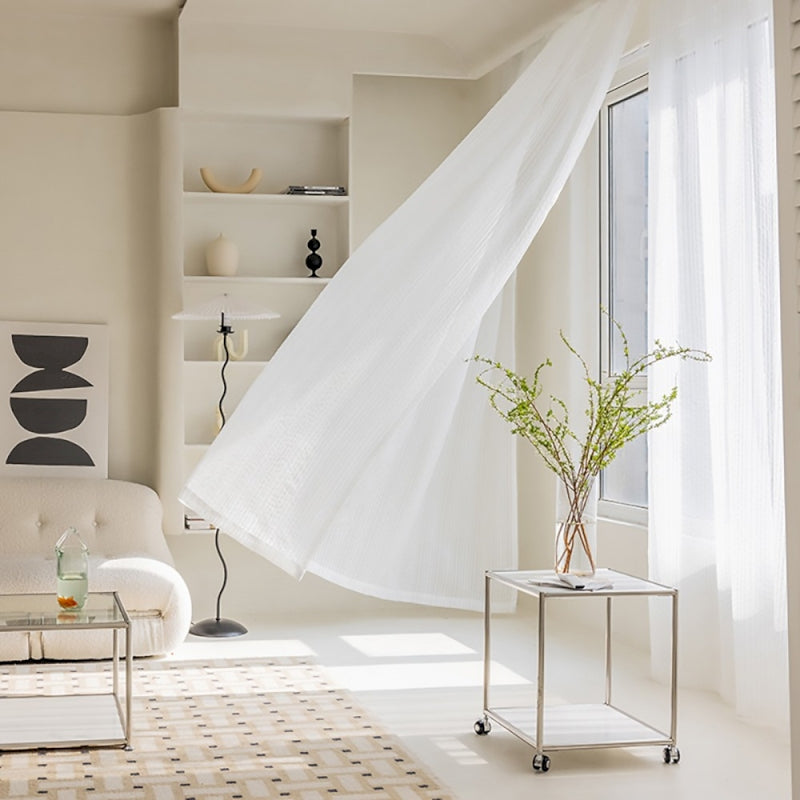 a living room with a white couch and white curtains