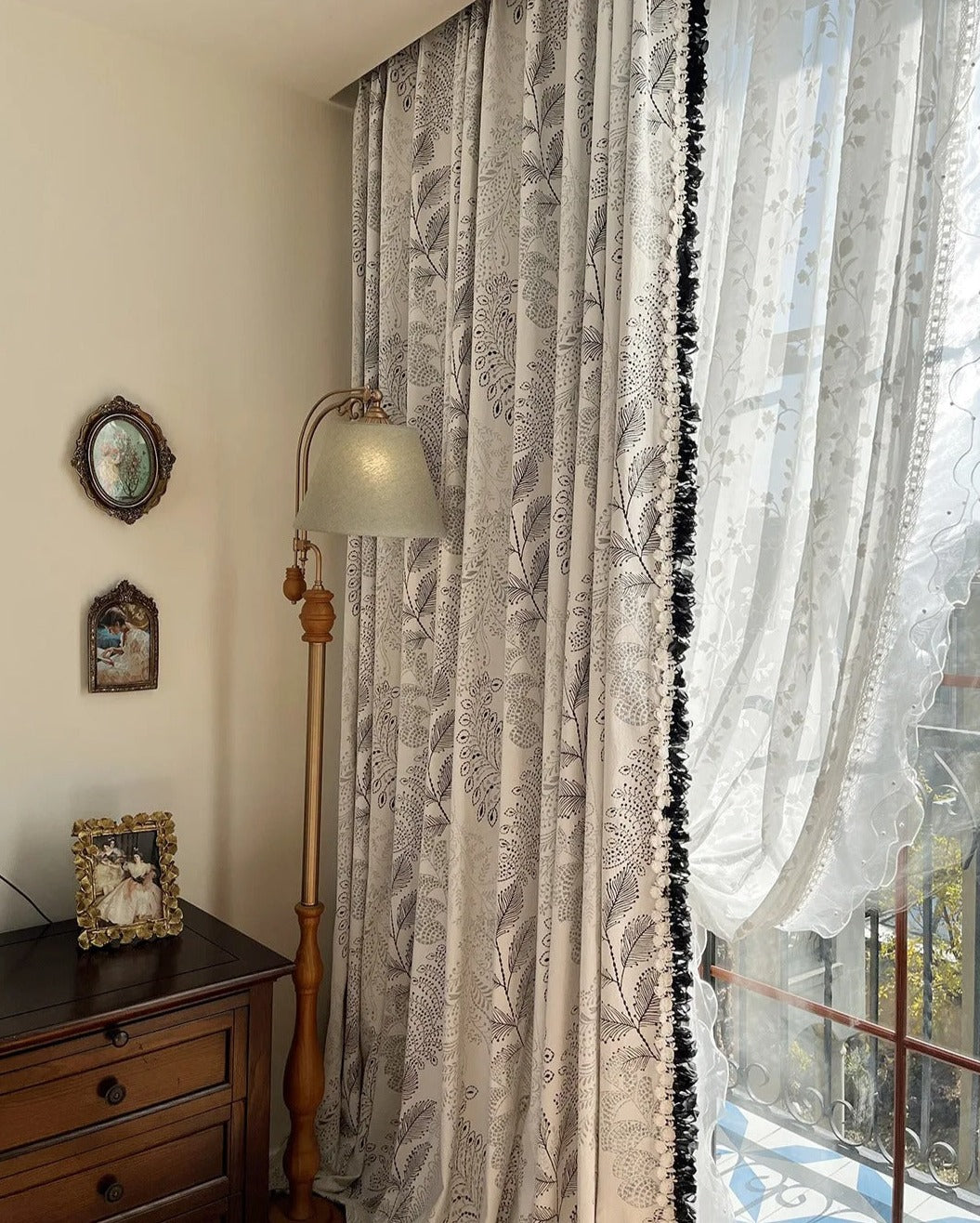 a window with a curtain and a lamp next to it