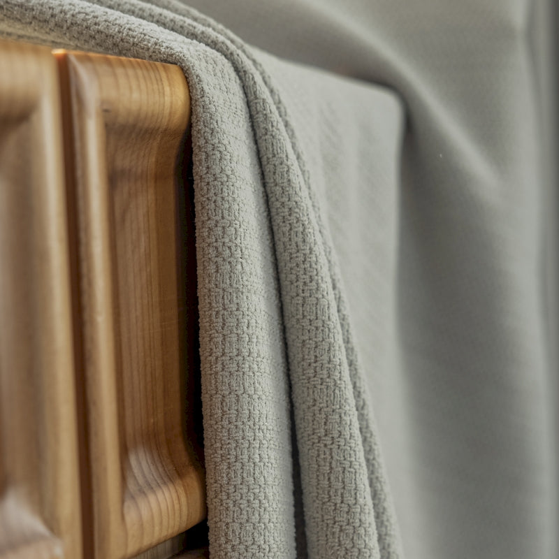 a close up of a bed with a wooden headboard