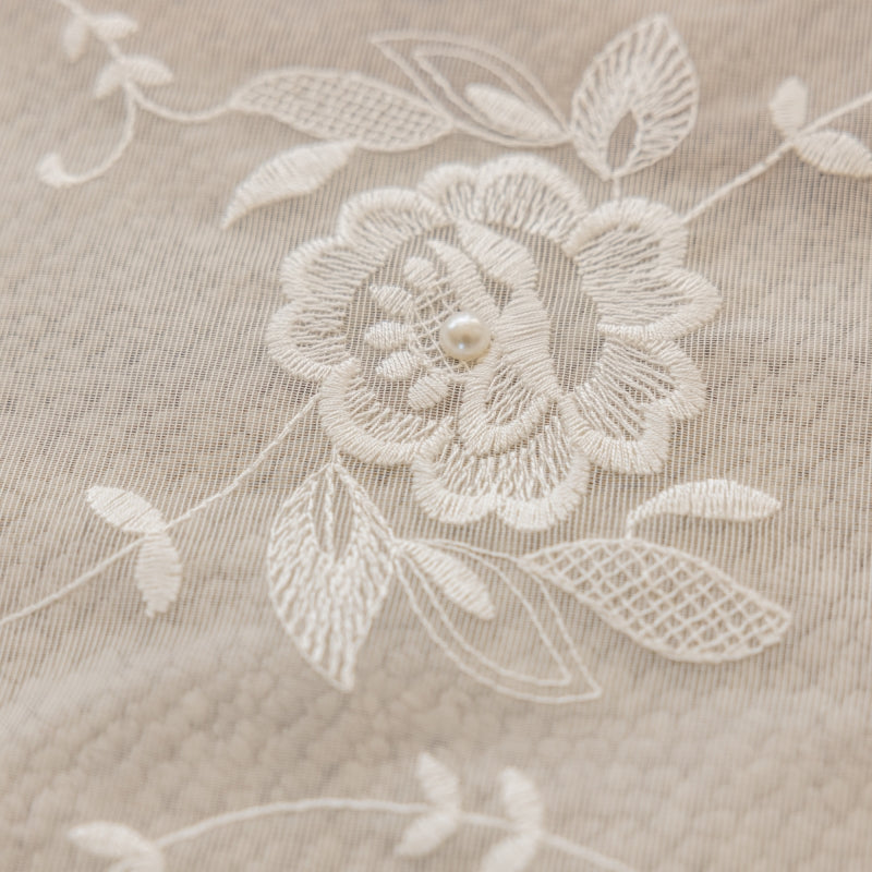 a close up of a flower on a bed sheet