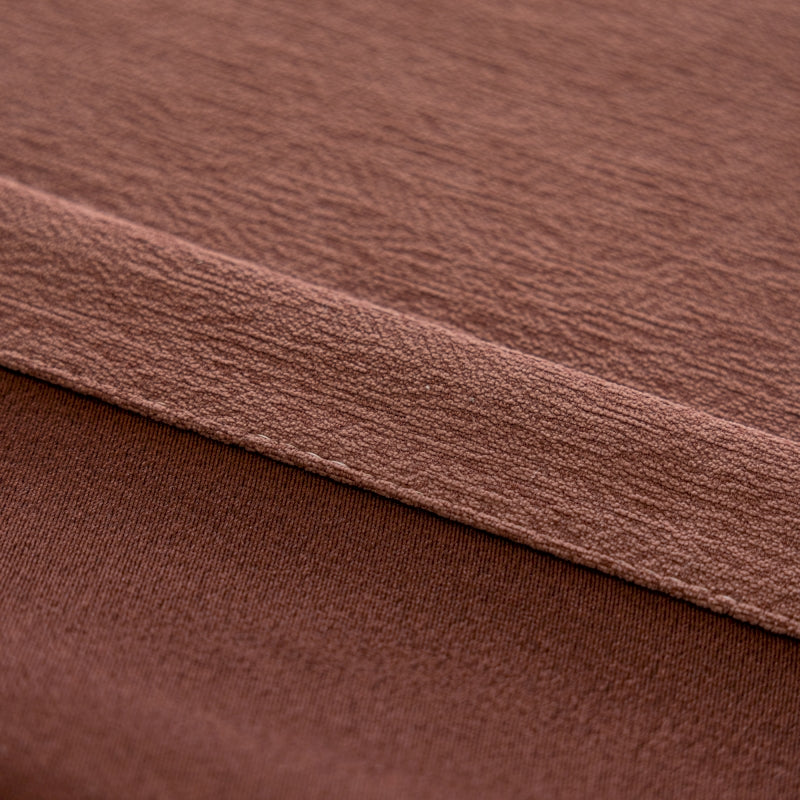a close up of a brown blanket on a bed