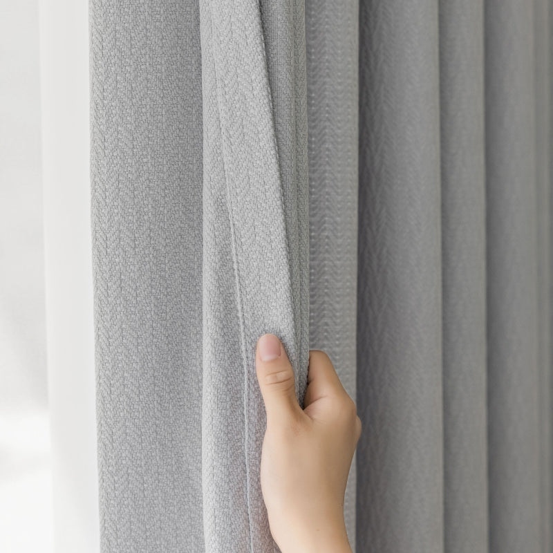 a hand that is holding a curtain in front of a window