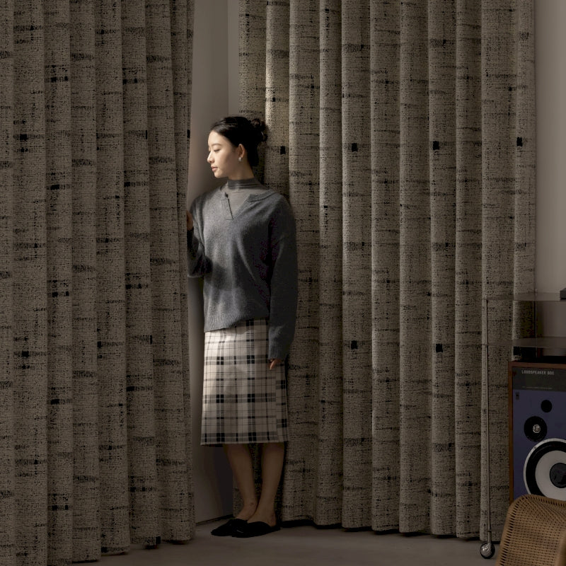 a woman standing in front of a curtain