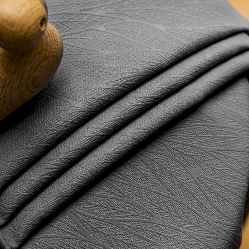 a close up of a black leather material with a wooden handle