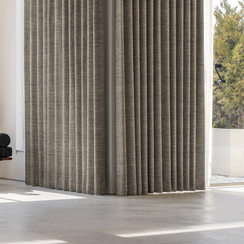 a living room with a large window covered in curtains