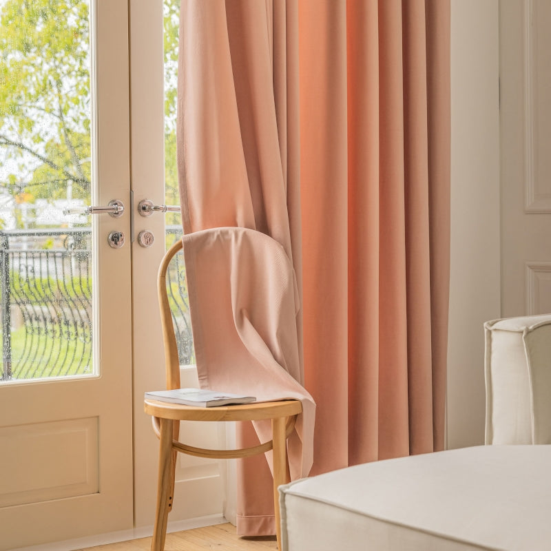 a chair sitting in front of a window next to a bed