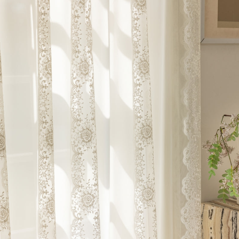 a window with a white curtain and a potted plant