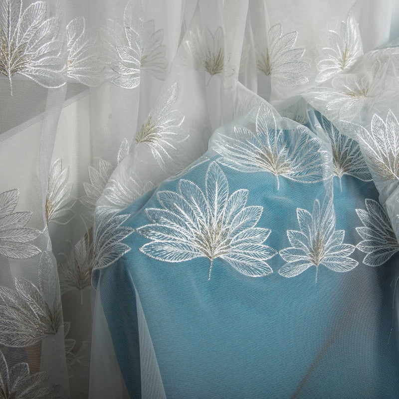 a blue and white curtain with white flowers on it
