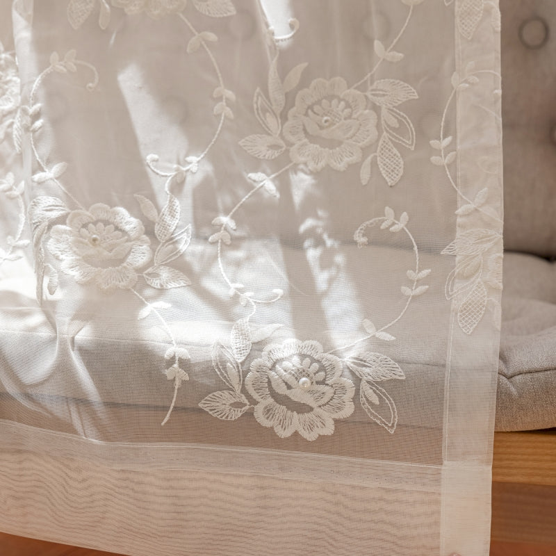 a close up of a sheer curtain with flowers on it