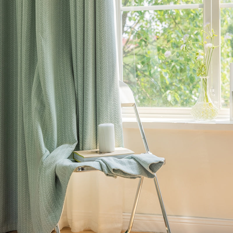 a chair with a towel on it next to a window