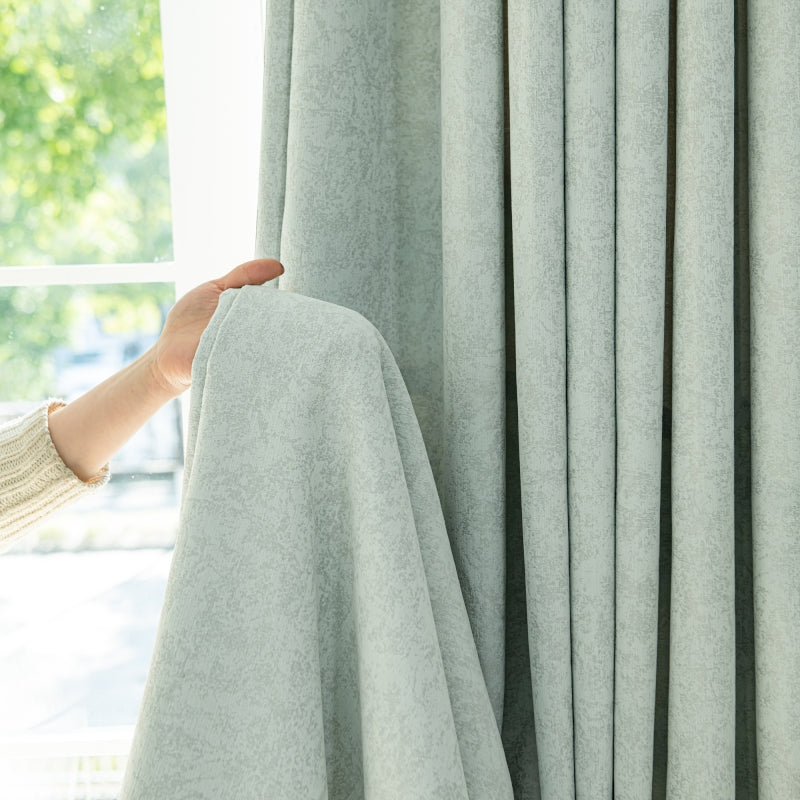 a woman is holding a blanket over a window