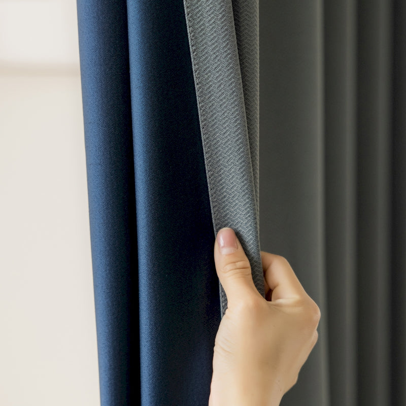 a person holding a curtain with their hand