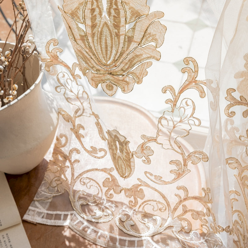 a close up of a sheer curtain near a potted plant