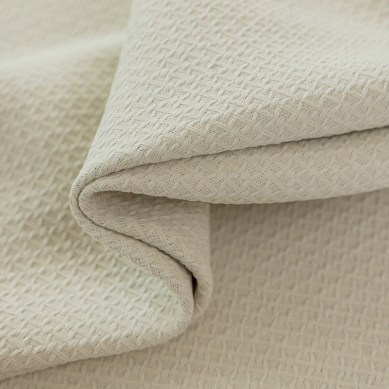 a close up of a white blanket on a bed