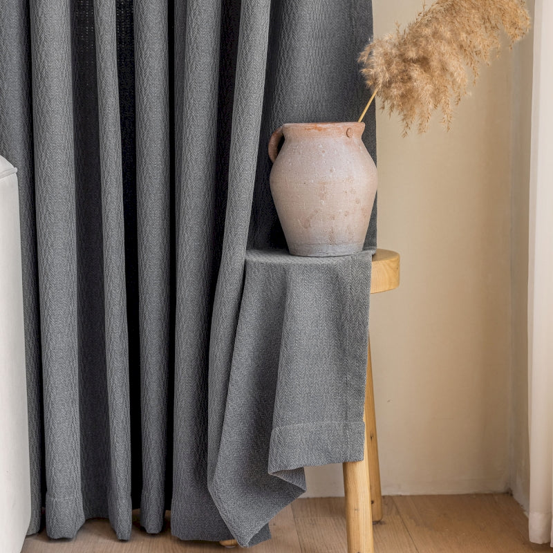a vase sitting on top of a table next to a curtain
