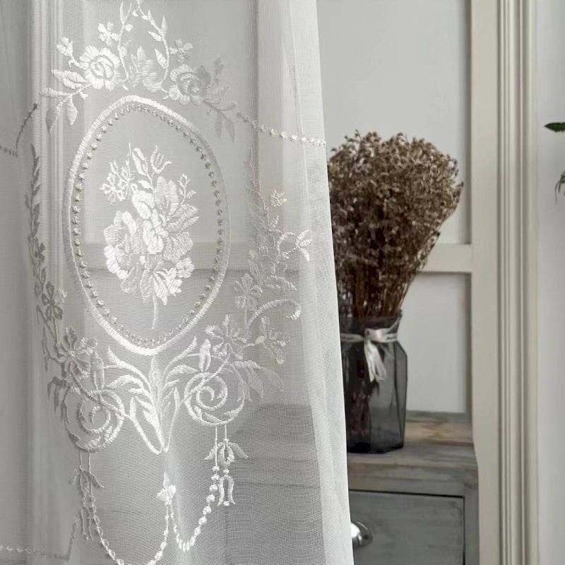 a white curtain with a floral design on it
