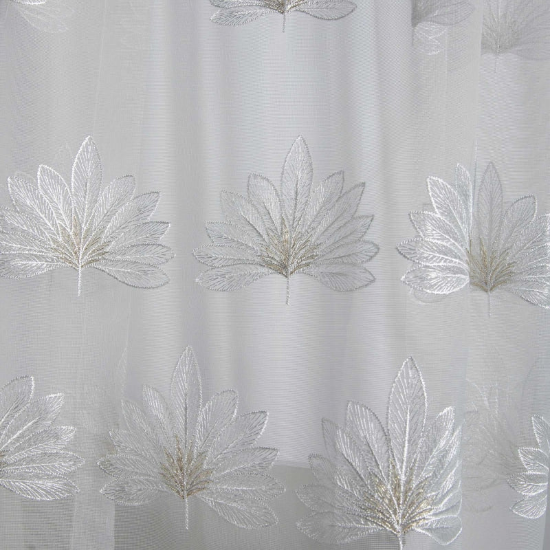 a close up of a shower curtain with leaves on it
