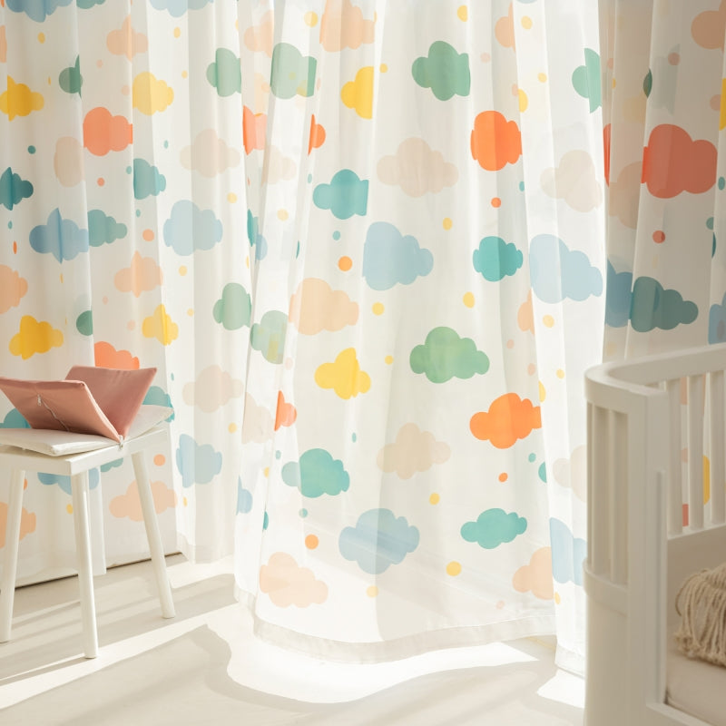 a child's room with a white crib and colorful clouds on the wall