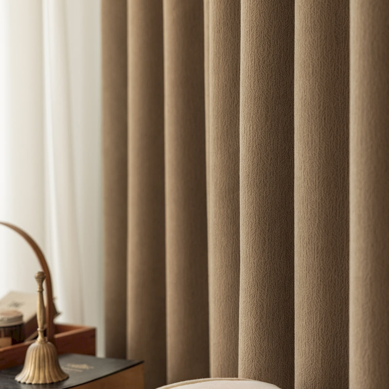 a room with a bed, desk, and curtains