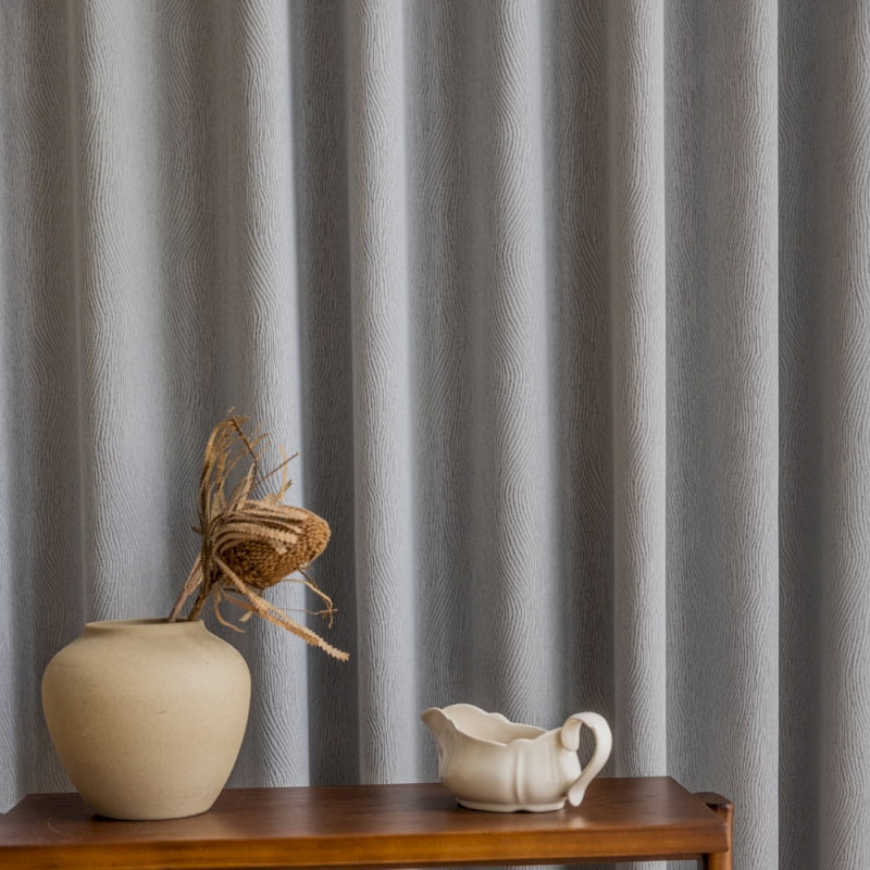a white vase sitting on top of a wooden table
