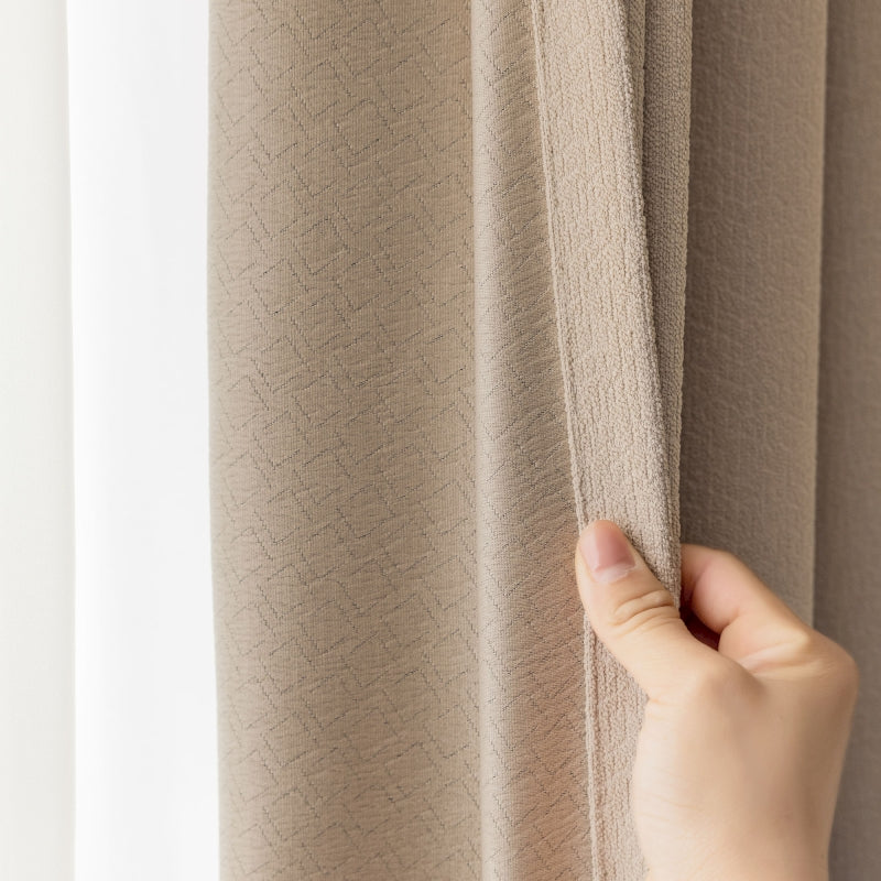 a person is holding a curtain in front of a window