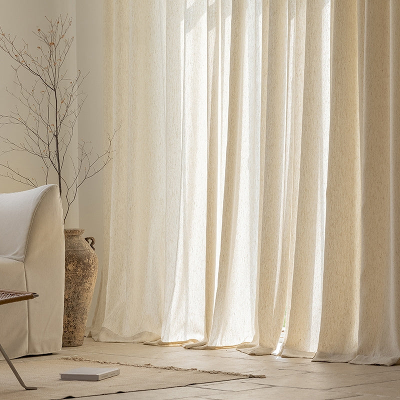 a living room with a white couch and white curtains