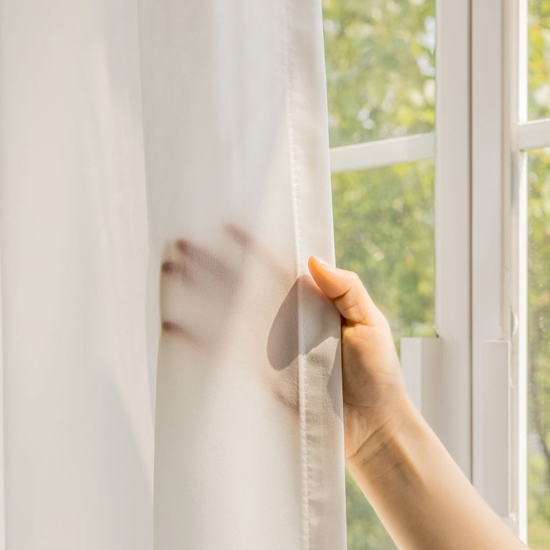 a person is holding a curtain in front of a window